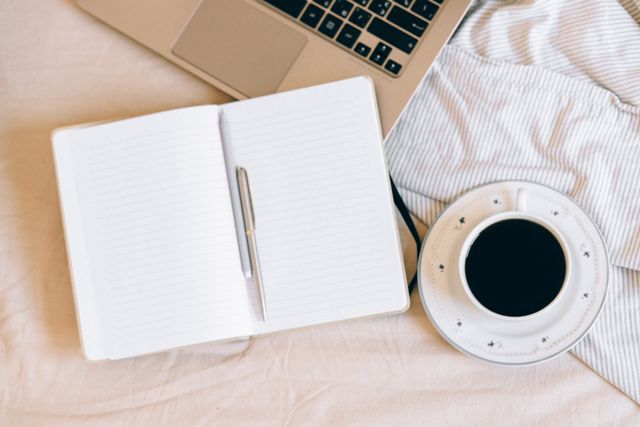Journal, laptop, coffee on a blnekt